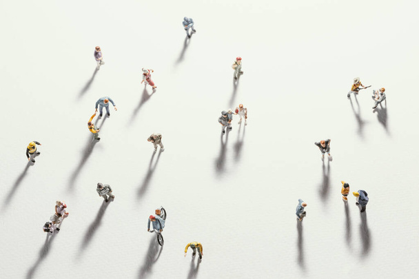 Top view of people (miniature toys) with long shadows keep distance away in public during sunrise or sunset.Social distancing during COVID-19 coronavirus outbreak spreading concept. - Foto, Imagen