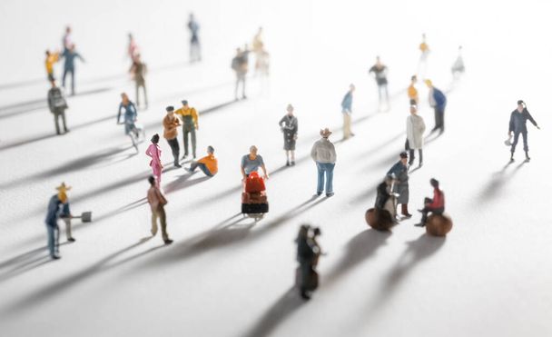 Top view of people (miniature toys) with long shadows keep distance in public during sunrise or sunset.Social distancing during COVID-19 coronavirus outbreak spreading concept. - Фото, изображение