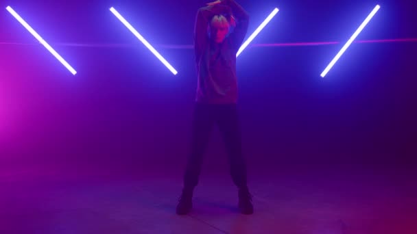 Profesjonalny wykonawca tańczący solo energicznie w podświetleniu studio liliowym. - Materiał filmowy, wideo