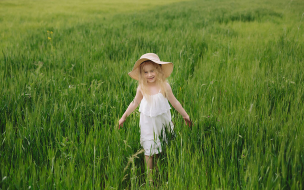 夏の暖かく、曇っている日にライ麦フィールドで歩いて長い髪の少女. - 写真・画像