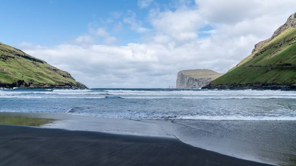 トールヌヴィク湾から見えるリシンとケリングインの岩で、波がフェロー諸島、デンマーク、ヨーロッパのストリーモイ島の海岸に打ち寄せる - 写真・画像