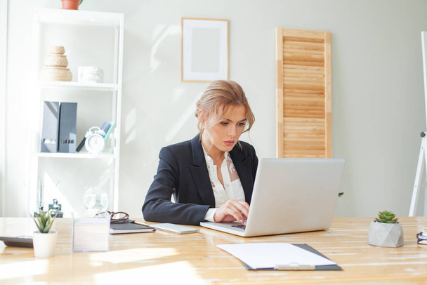 Smart businesswoman using laptop in the workspace - Zdjęcie, obraz