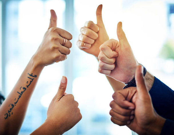 Yes We are the best team. Cropped shot of a group of unrecognizable businesspeople showing thumbs up in a modern office. - Фото, изображение