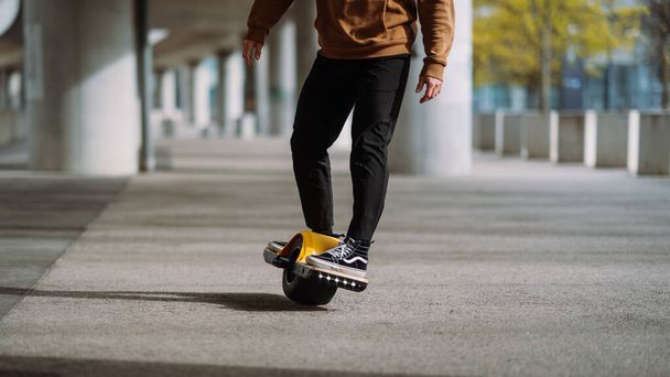 Κοντινό πλάνο πόδι ενός σκέιτερ με ηλεκτρικό skateboard. - Φωτογραφία, εικόνα