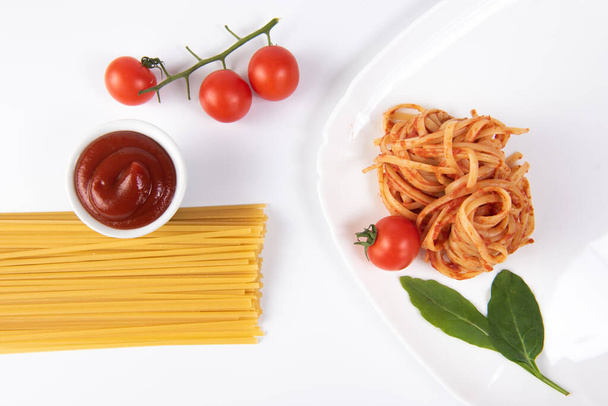 pasta with tomato sauce and basil on white dish. - Foto, afbeelding