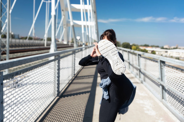 Young woman starting new life after car crash accident or heavy illness with morning routine of exercising running and jogging outdoor. Female sport person stretching muscles before workout. - Photo, Image