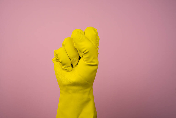 the fist from a hand wearing a yellow rubber glove - Foto, Imagen