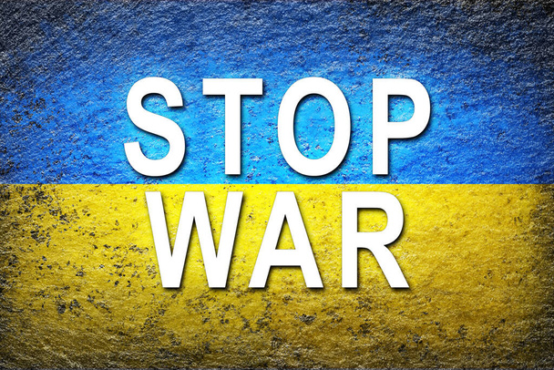 Bandera de Ucrania. La bandera ucraniana con un gran eslogan blanco STOP WAR está pintada sobre una superficie rugosa. Fondo creativo. - Foto, imagen