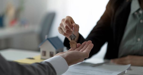 Close up hand of home,apartment agent or realtor was holding the key to the new landlord,tenant or rental.After the banker has approved and signed the purchase agreement successfully.Property concept - 写真・画像