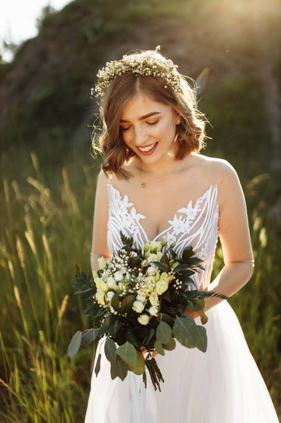 όμορφη νύφη σε λευκό φόρεμα με μπουκέτο λουλούδια  - Φωτογραφία, εικόνα
