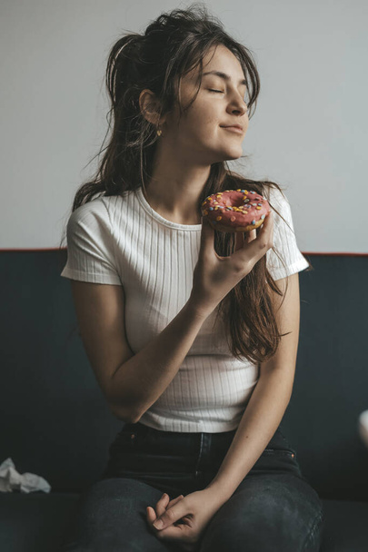 primer plano retrato de complacido bonita chica comer donuts - Foto, Imagen