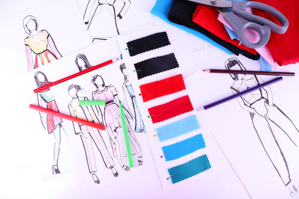 Sketches of clothes and fabric samples on table - 写真・画像