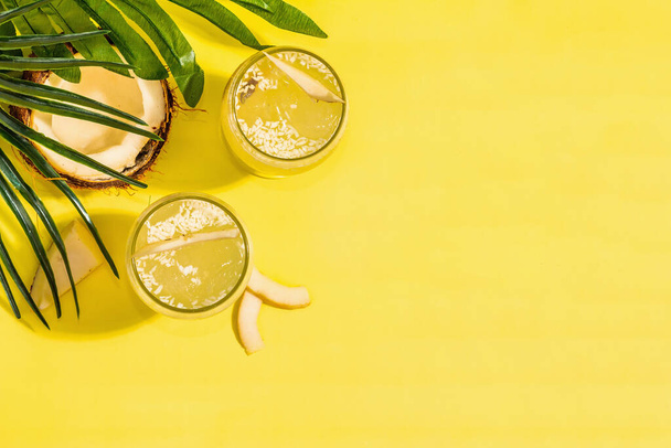 Refreshing summer Coconut martini. Non-alcoholic Margarita cocktail, trendy hard light, dark shadow.Bright yellow background, top view - Zdjęcie, obraz