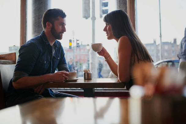 Reenacting their first date. Cropped shot of an affectionate young couple sitting in a coffee shop while on a date. - 写真・画像