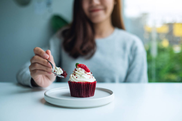 Krásná asijská žena těší jíst červený samet pohár dort - Fotografie, Obrázek