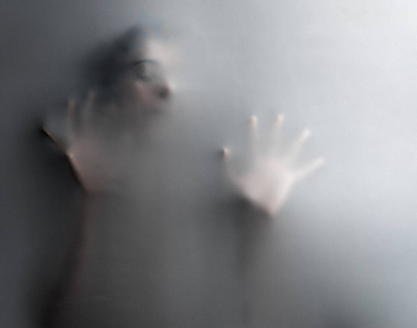 Cropped shot of an unrecognizable woman trapped behind a hazy film. - Foto, imagen