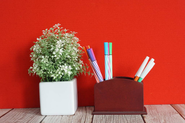 artificial flower with pens on the table - Photo, image