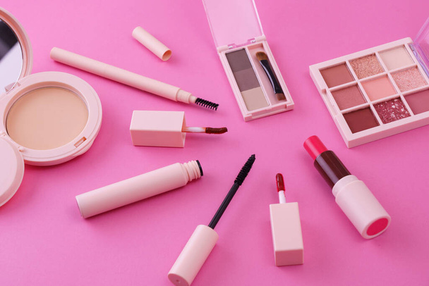 Een set van make-up tools geplaatst op een roze achtergrond - Foto, afbeelding