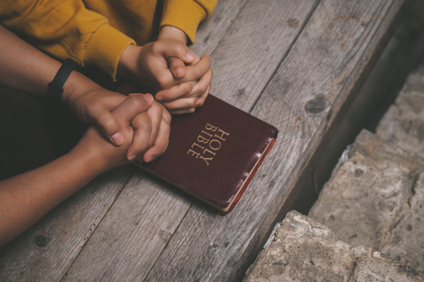 Close-up twee christelijke lees bijbel. Handen gevouwen in gebed op een Heilige Bijbel op houten tafel. online groep aanbidding, Werelddag van het gebed, internationale dag van het gebed, hoop, dankbaarheid, dankbaar, vertrouwen - Foto, afbeelding