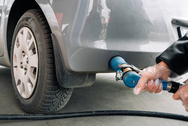 Pumping gas fuel car at oil station. Woman hand refuel petrol nozzle tank. Refueling transportation and Automotive industry - Foto, Imagem