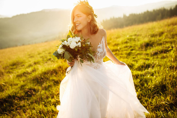beautiful bride in a white dress posing at nature - Fotó, kép