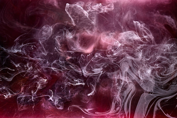 Black and red ink background, colorful fog, abstract swirling ocean, acrylic paint pigment underwater, white smoke - Photo, Image