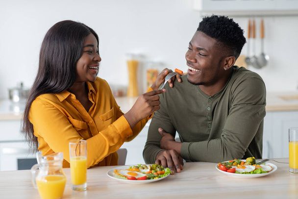 alegre negro pareja engañando mientras tener desayuno en cocina juntos - Foto, imagen