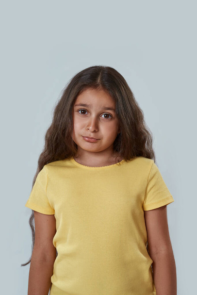 Front view of confused little girl look at camera - Фото, зображення