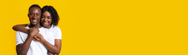 banner orizzontale con felice coppia nera che abbraccia su sfondo giallo - Foto, immagini