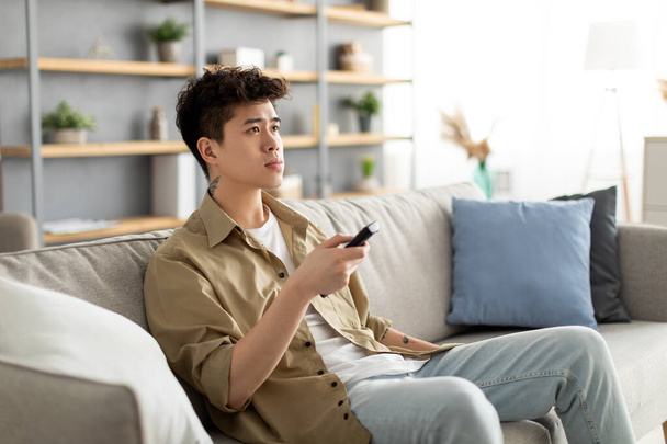 Young Asian guy spending weekend watching tv - Foto, Imagem