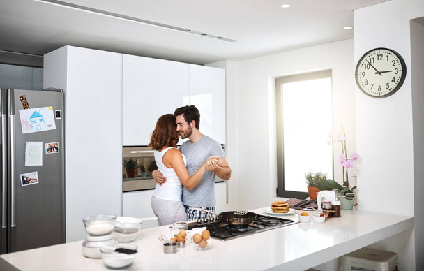 Ближе, чем мы могли себе представить. Снимок молодой пары, танцующей на кухне во время приготовления завтрака. - Фото, изображение