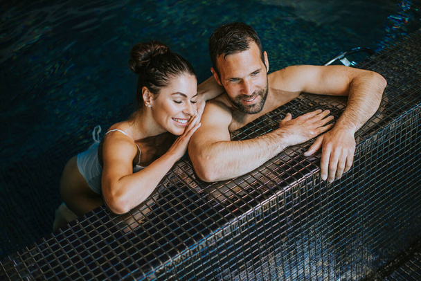 Hezký pár relaxaci v krytém bazénu - Fotografie, Obrázek