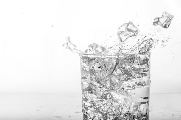 Spatten van water met ijs in glas - Foto, afbeelding