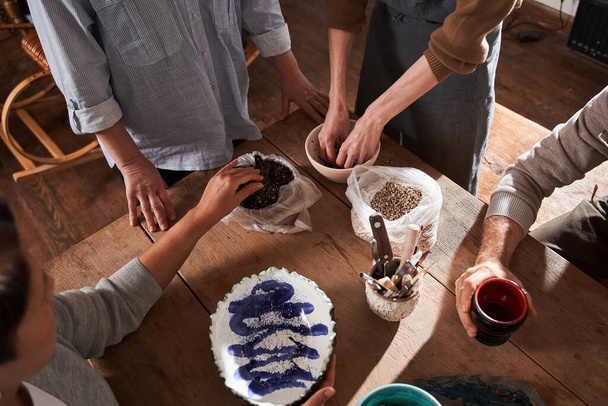 People preparing glazing their handmade clay dishes while having master class with the teacher - Fotoğraf, Görsel