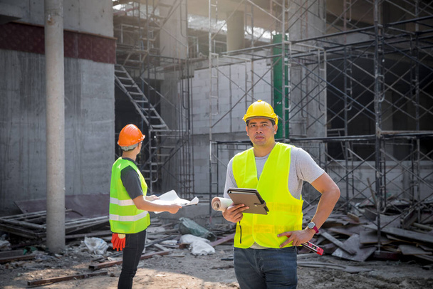 Arquitecto, Ingeniero, Contratista, o Gerente de Construcción sosteniendo tableta digital de pie en un sitio de construcción. - Foto, Imagen