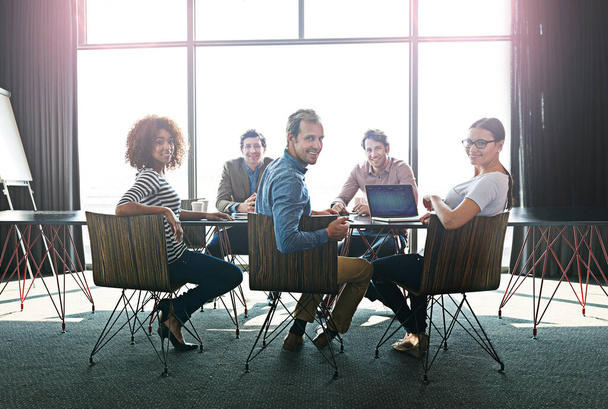 Reunión de profesionales de ideas afines. Retrato de un grupo de colegas de oficina sentados alrededor de una mesa de juntas. - Foto, imagen