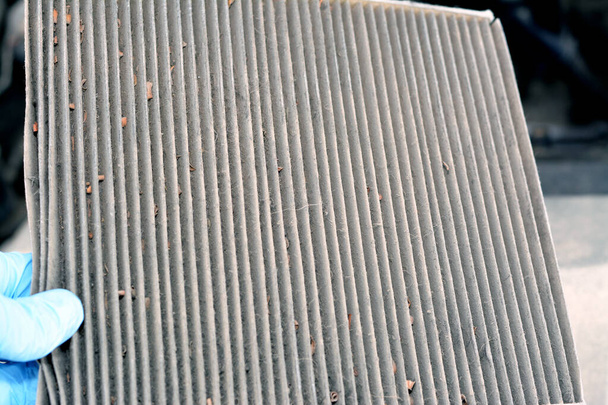 Detailní záběr starého špinavého ojetého vozu AC klimatizační filtr plný prachu odstraněného z vozidla, který má být nahrazen novým, kabinový vzduchový uhlíkový filtr, obdélníkový, pěnový gumový těsnicí proužek - Fotografie, Obrázek