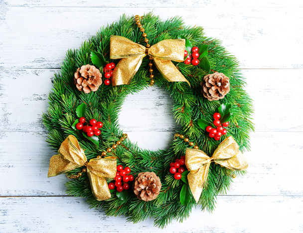 Christmas decorative wreath with leafs of mistletoe on wooden background - Foto, afbeelding