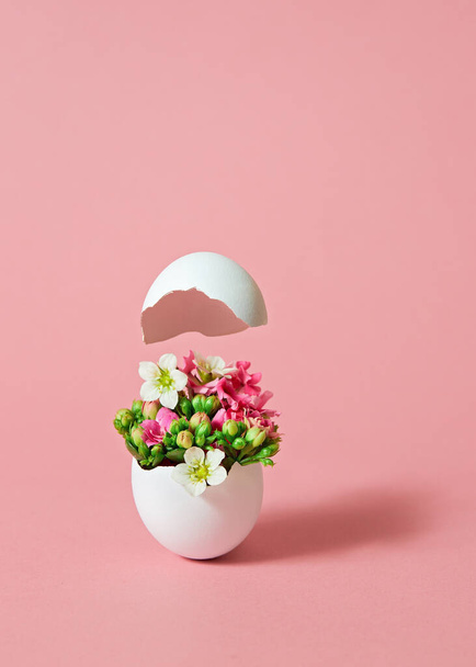 White Easter egg with beautiful spring flowers on pink background. Easter spring concept with copy space.  - Fotoğraf, Görsel