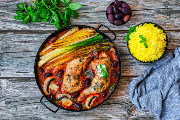 Oven roasted chicken legs with grilled leek, olives and mushroom in tomato sauce, served with saffron rice - 写真・画像