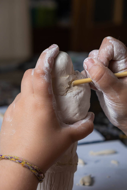 Primo piano delle mani di una ragazza che fa una figura di argilla. artigianato per bambini - Foto, immagini