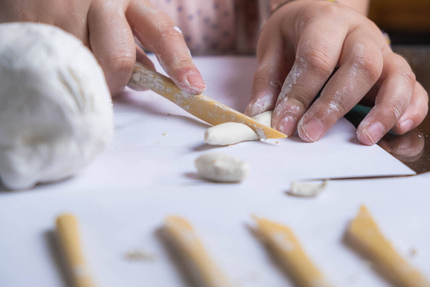 Dettaglio foto delle mani di una ragazza che taglia argilla. artigianato per bambini - Foto, immagini