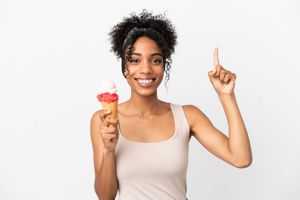 Mladá africká americká žena s kornetovou zmrzlinou izolované na bílém pozadí ukazuje na skvělý nápad - Fotografie, Obrázek