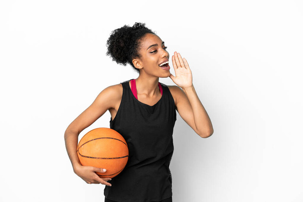 Jeune joueur de basket-ball femme latine isolée sur fond blanc criant avec la bouche grande ouverte sur le côté - Photo, image