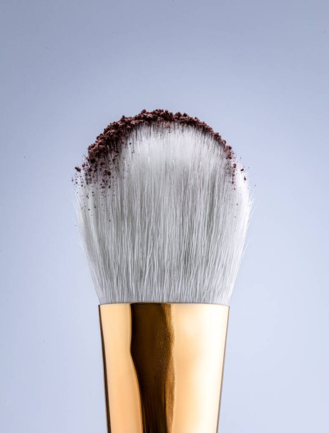 Cosmetic product of brown powder with a gray brush for a makeup artist. Macro photography - Foto, Imagem