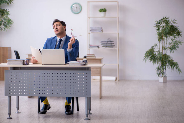 Jeune employé masculin assis dans le bureau - Photo, image