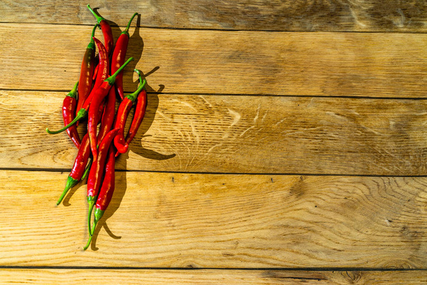 červené chilli papričky na dřevěném prkénku. - Fotografie, Obrázek