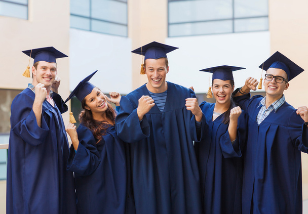 group of smiling students in mortarboards - Foto, afbeelding