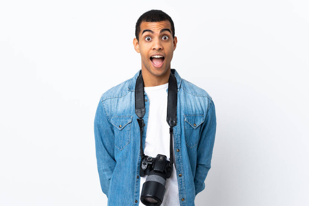 Junger afroamerikanischer Fotograf vor isoliertem weißen Hintergrund mit überraschendem Gesichtsausdruck - Foto, Bild