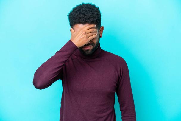 Young Brazilian man isolated on blue background with headache - Foto, afbeelding